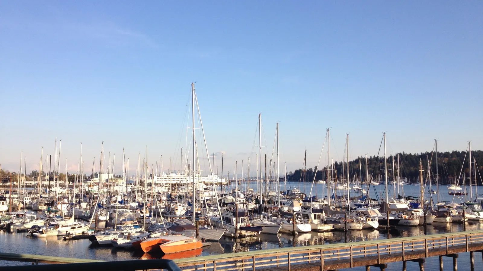 Boats moored at Eagle Harbor on Bainbridge Island, with the ferry terminal in the distance.