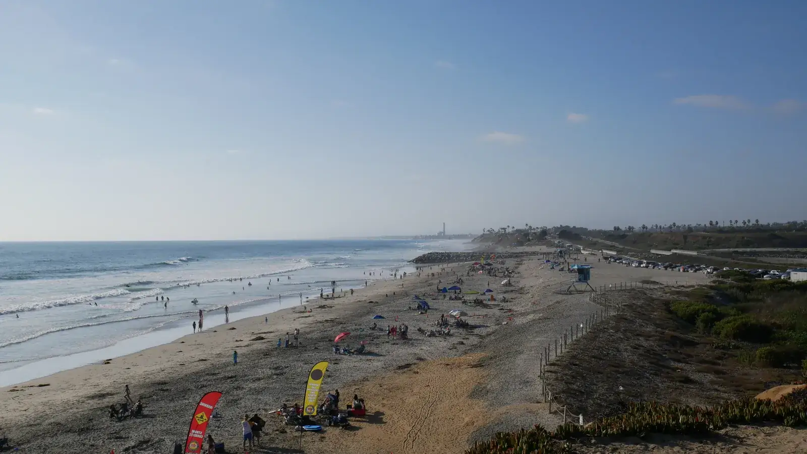South Carlsbad State Beach, with bluffs above a sandy shore and people on the sand.