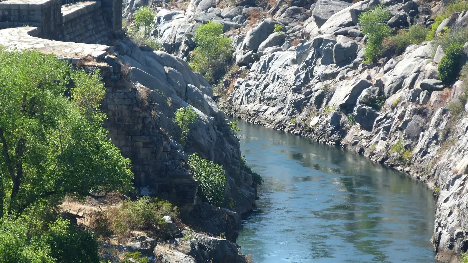 The old dam on the American River at Folsom, with trees along the bank.