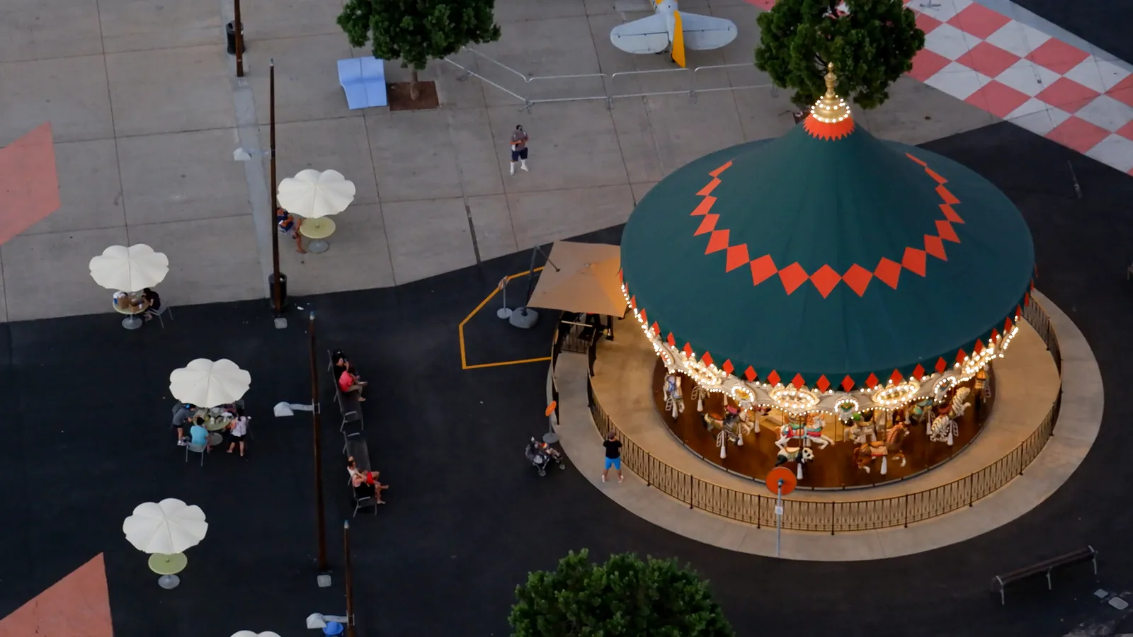 The carousel at Great Park, seen from the balloon, with a red roof and a circular plaza.